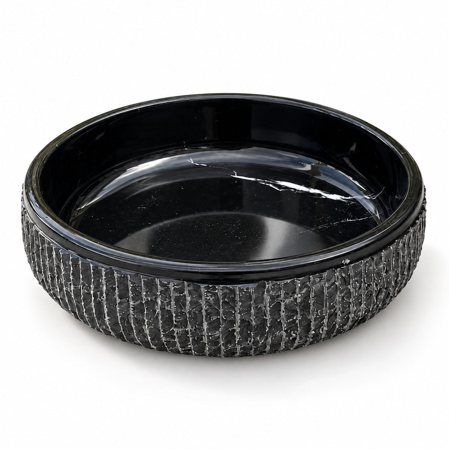 Black textured marble decorative bowl on a travertine coffee table in a living room