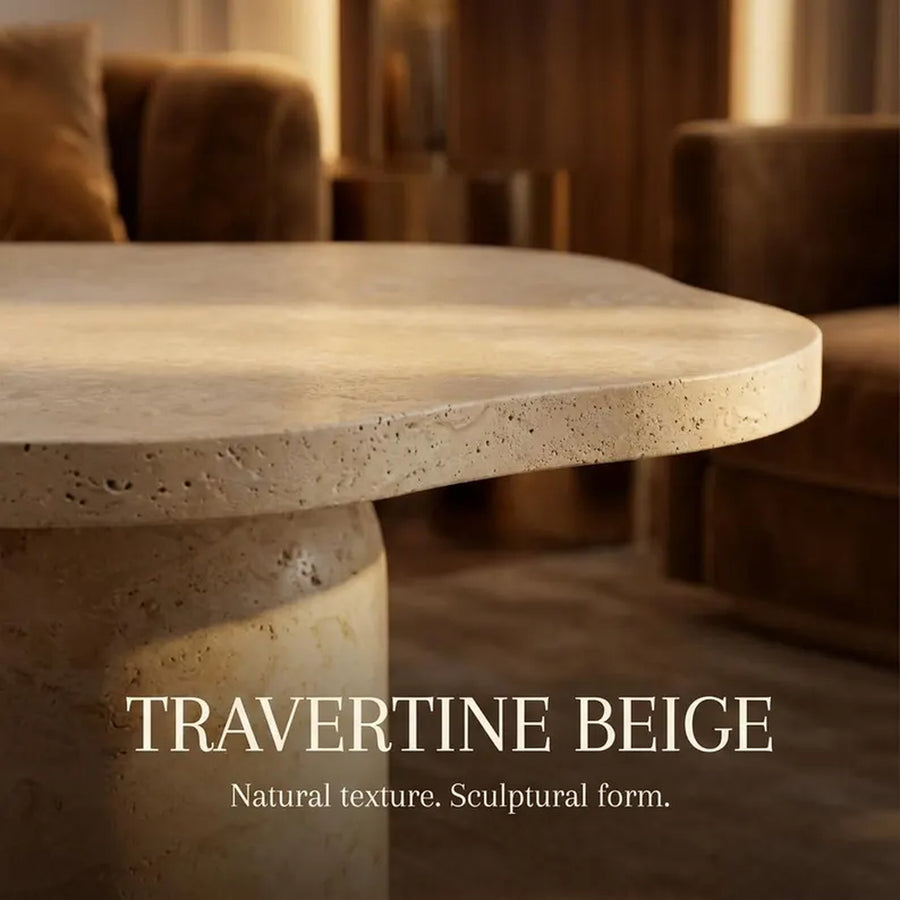 A close-up of a travertine beige stone table in a warm, modern living room setting, with the text 'TRAVERTINE BEIGE' and 'Natural texture. Sculptural form.