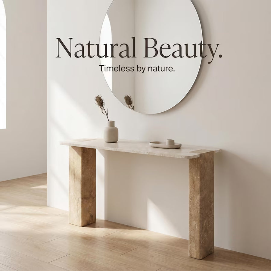 A minimalist interior scene with a white console table, a round wall mirror, and a small beige vase with dried stems. Large text on the wall reads 'Natural Beauty.