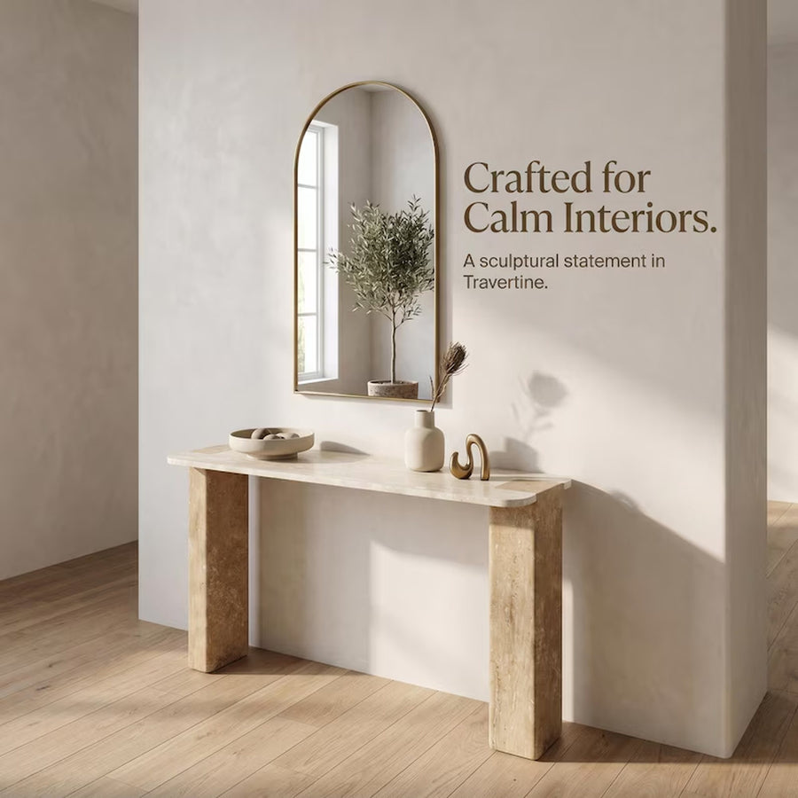 A styled interior scene showing a light stone console table against a warm beige wall, with an arched mirror, small vase, bowl, and decorative branch. Text on the wall reads, 'Crafted for Calm Interiors.