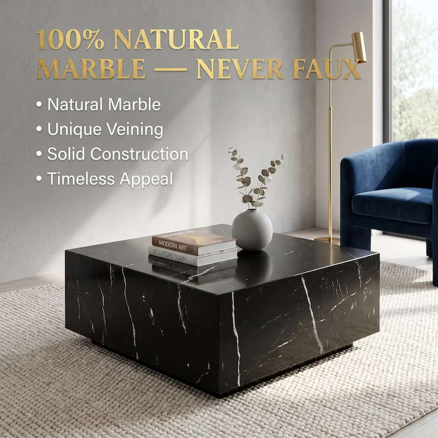 A glossy black marble coffee table with white veining, styled in a modern living room setting with a blue armchair, gold floor lamp, and decorative books and vase. Text overlays on the left read '100% NATURAL MARBLE — NEVER FAUX' with bullet points highlighting natural marble, unique veining, solid construction, and timeless appeal.