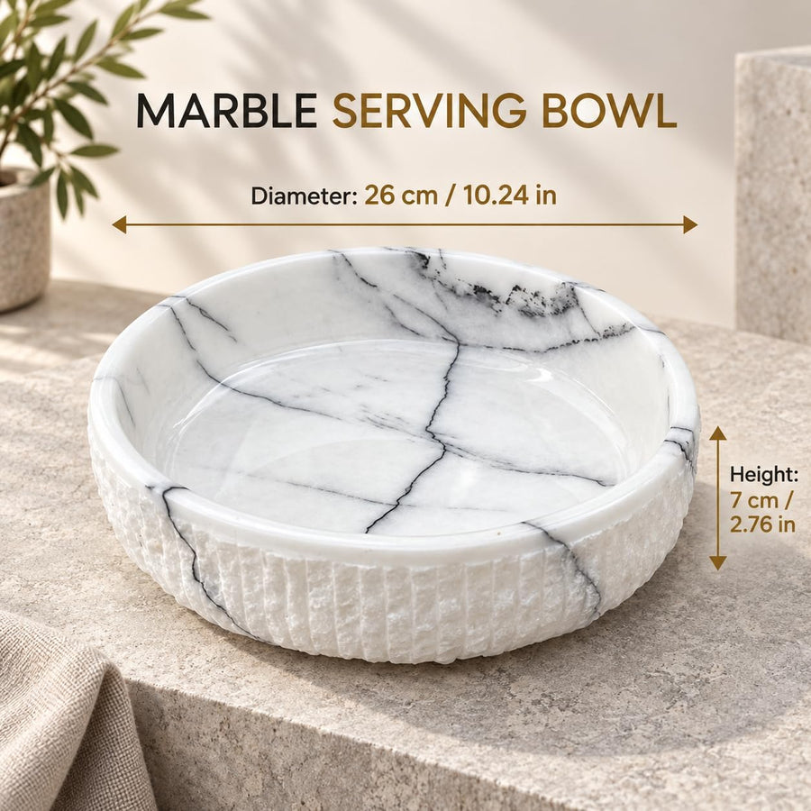 The Footed Lilac Marble Platter is a hand-carved natural stone platter raised on a foot, made from Lilac Marble. Its soft lilac veining and raised foot make it as pretty on a vanity as it is on a dessert table.