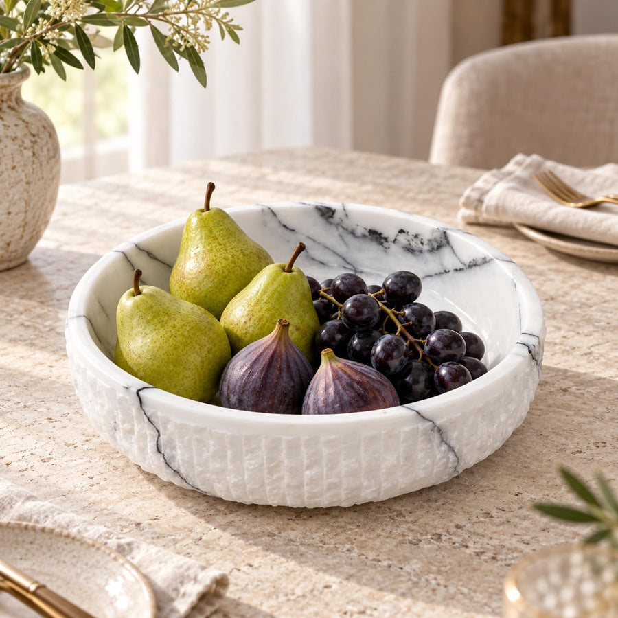 The Footed Lilac Marble Platter is a hand-carved natural stone platter raised on a foot, made from Lilac Marble. Its soft lilac veining and raised foot make it as pretty on a vanity as it is on a dessert table.