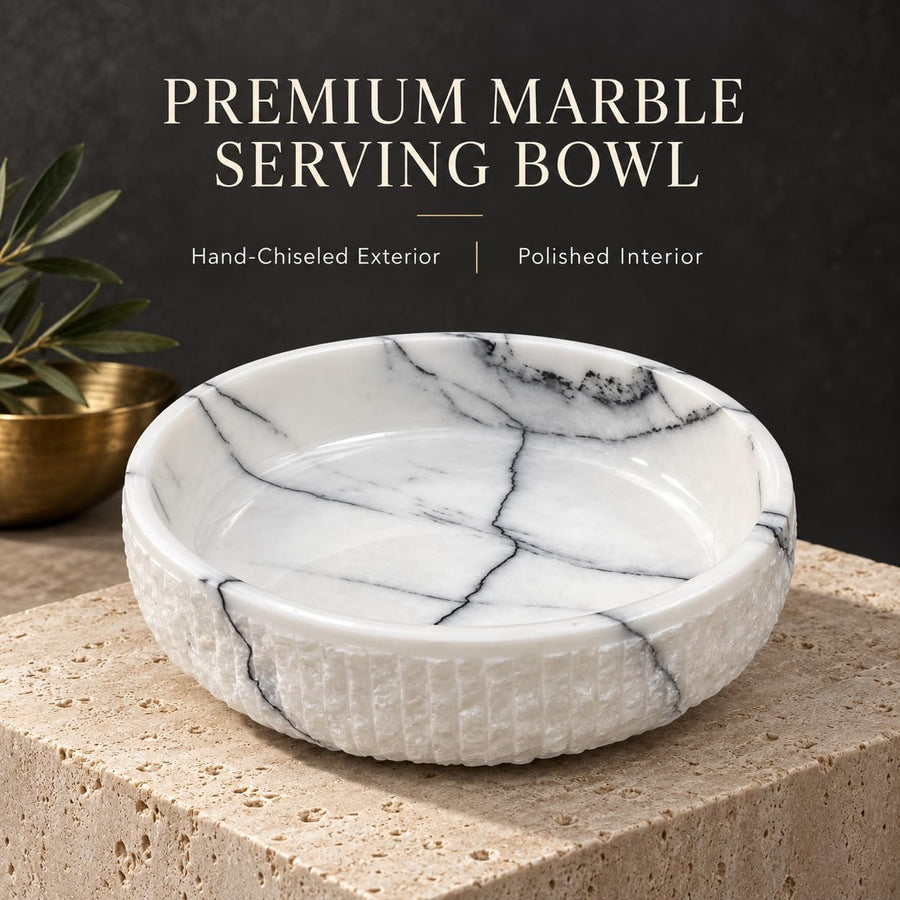 The Footed Lilac Marble Platter is a hand-carved natural stone platter raised on a foot, made from Lilac Marble. Its soft lilac veining and raised foot make it as pretty on a vanity as it is on a dessert table.