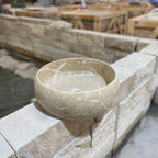 Stone bowl on a stone ledge with construction materials in the background