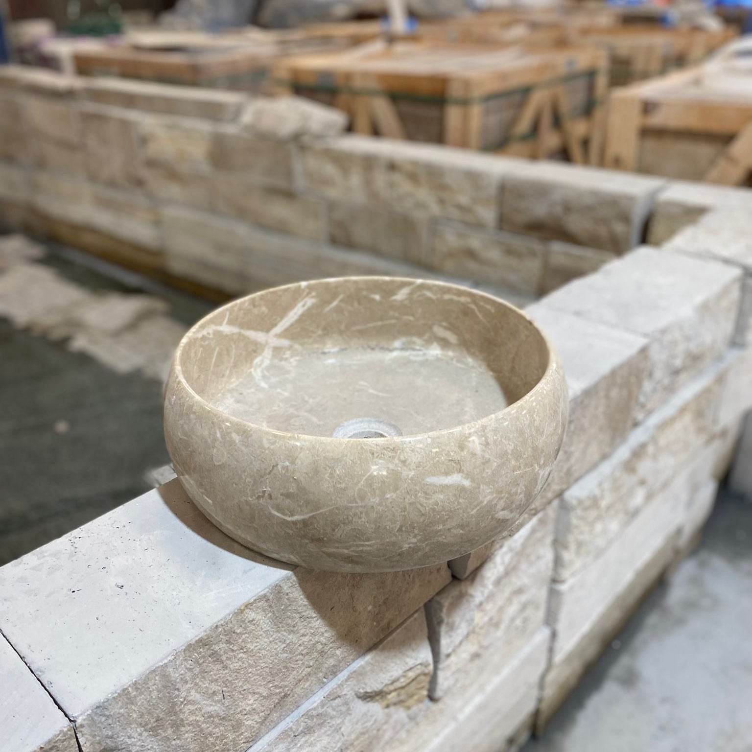 Stone bowl on a stone ledge with construction materials in the background