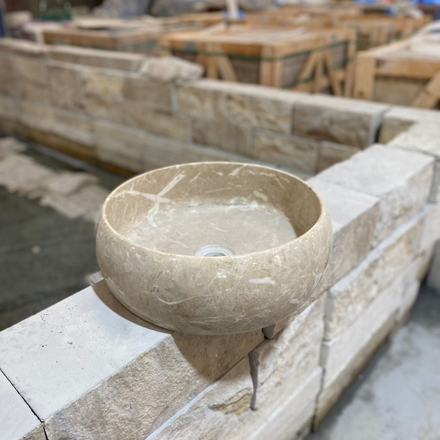Stone bowl on a stone ledge with construction materials in the background