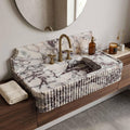 Marble-patterned sink with gold faucet in a bathroom setting