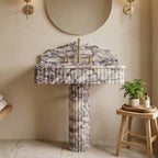 Calacatta viola marble pedestal sink in a bathroom setting with a stool and plant.