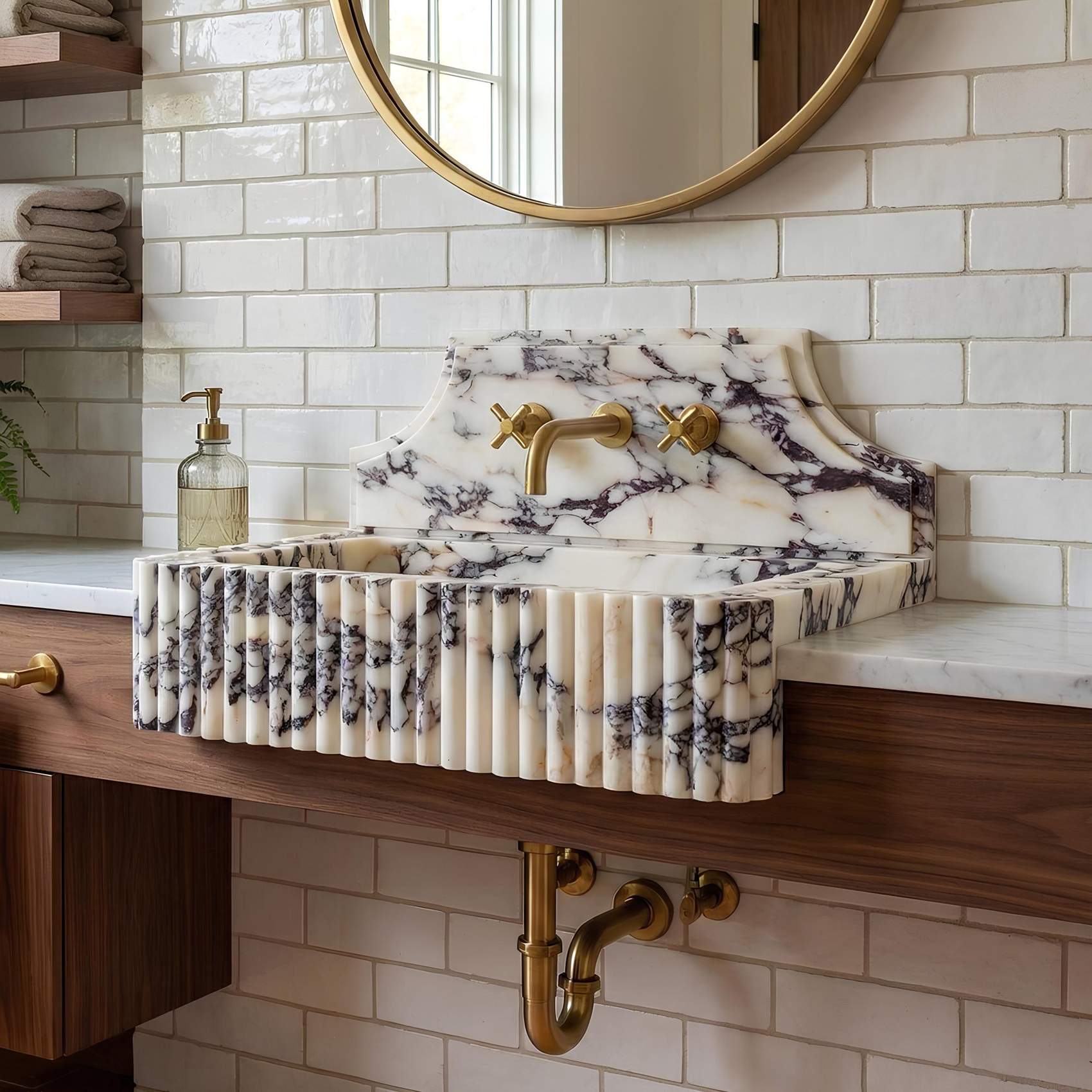 Marble-patterned sink with gold fixtures in a bathroom setting