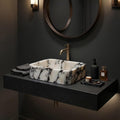 Black and white marble sink on brass console legs with a marble lower shelf