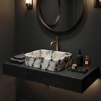 Black and white marble sink on brass console legs with a marble lower shelf