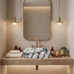 Black and white marble sink on a wood floating shelf in an olive green bathroom with black fixtures