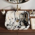 Top view of black and white marble sink with brass faucet on walnut counter