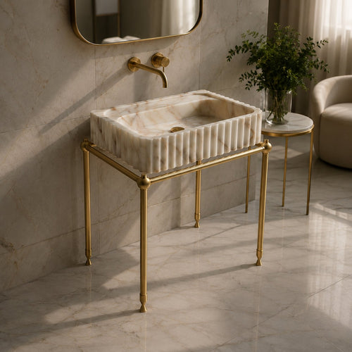 Calacatta Gold marble fluted vessel sink on a brass washstand with wall-mounted brass faucet