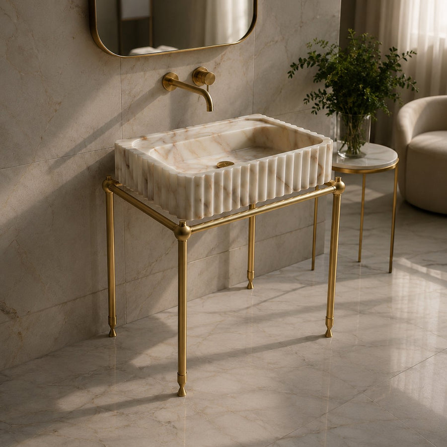 Calacatta Gold marble fluted vessel sink on a brass washstand with wall-mounted brass faucet