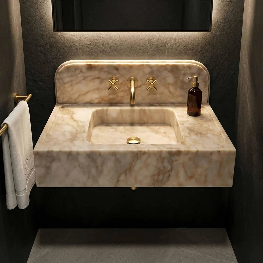 Marble sink with gold faucet in a bathroom setting