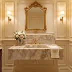 Luxurious bathroom with marble sink, gold fixtures, and decorative mirror.