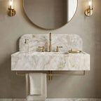 Bathroom sink with marble countertop, gold fixtures, and round mirror.