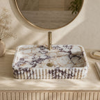 Calacatta Viola marble fluted vessel sink on a wood vanity with brass faucet