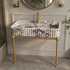 Calacatta Viola marble sink on brass washstand legs in a paneled bathroom
