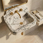 Marble sink with gold fixtures in a bathroom setting
