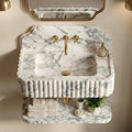 Marble sink with gold fixtures in a bathroom setting