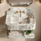 Marble sink with gold fixtures in a bathroom setting