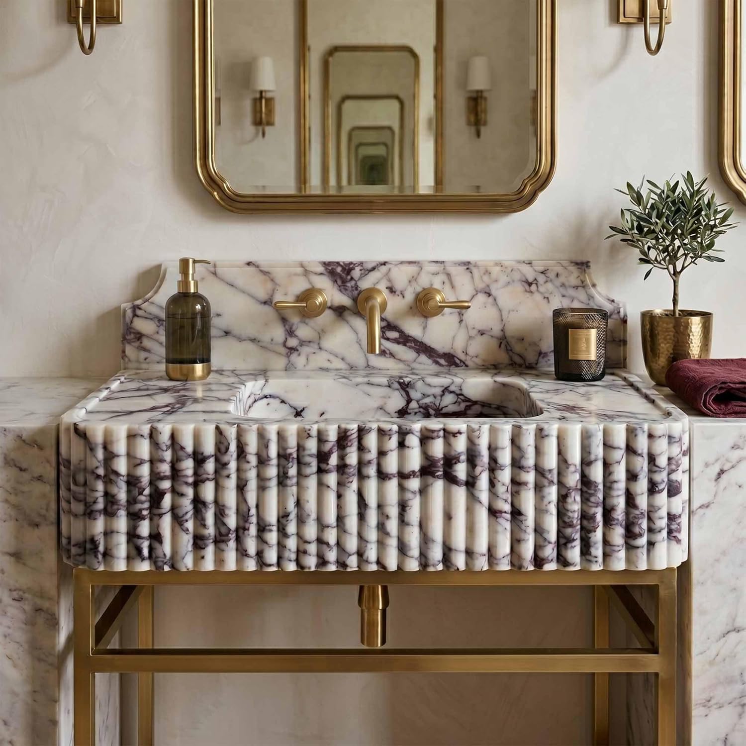 Marble sink with gold fixtures in a bathroom setting