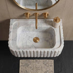 Marble sink with gold fixtures in a bathroom setting