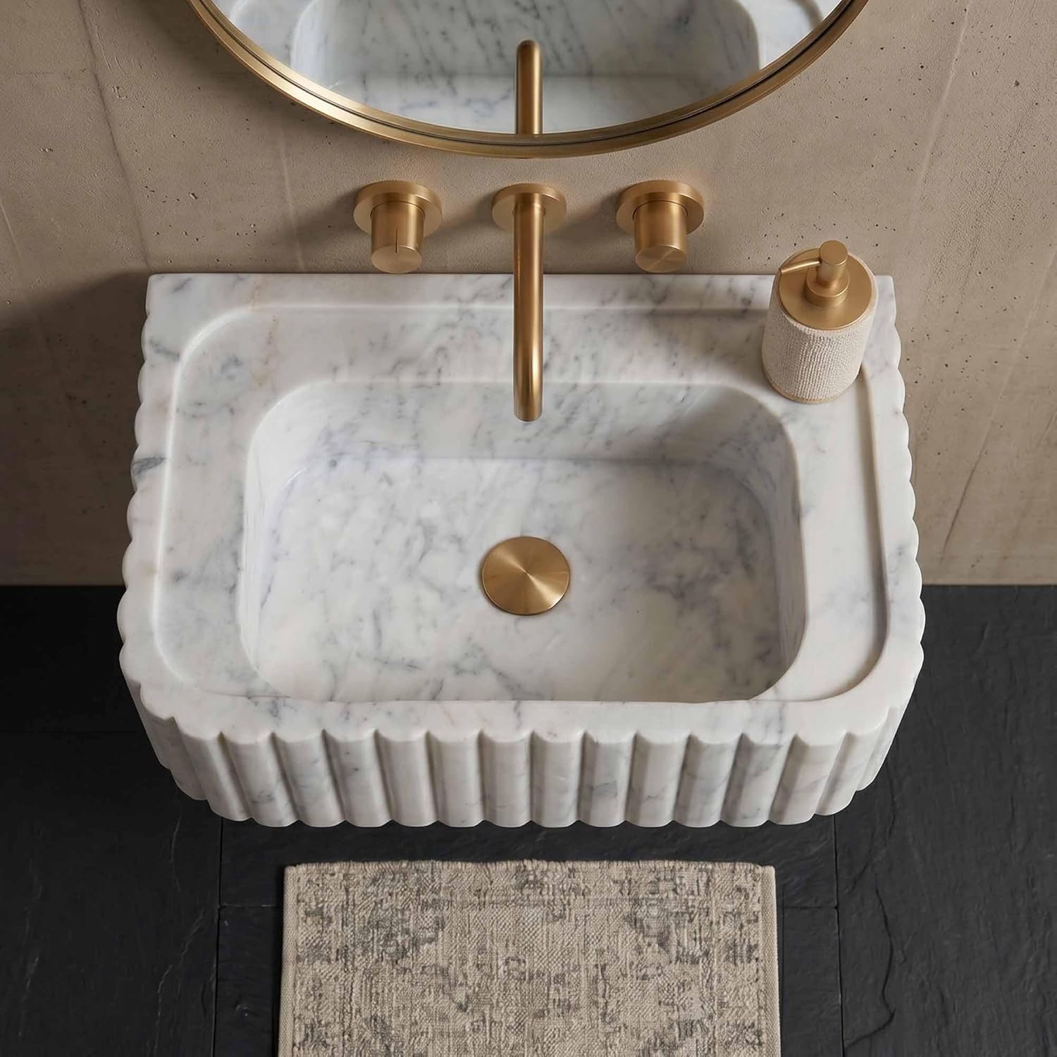 Marble sink with gold fixtures in a bathroom setting
