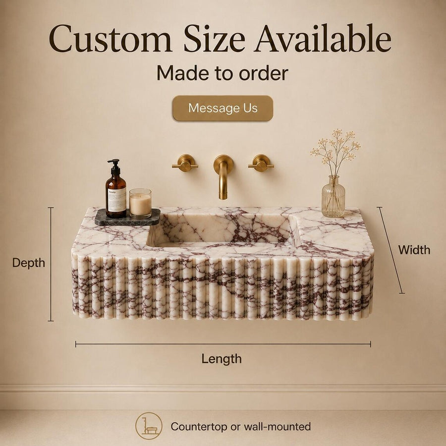 A freestanding rectangular sink with a fluted marble-look front, shown against a beige wall with gold faucet hardware. The image includes overlaid text reading 'Custom Size Available' and dimension labels for depth, width, and length, plus small decorative objects on top.