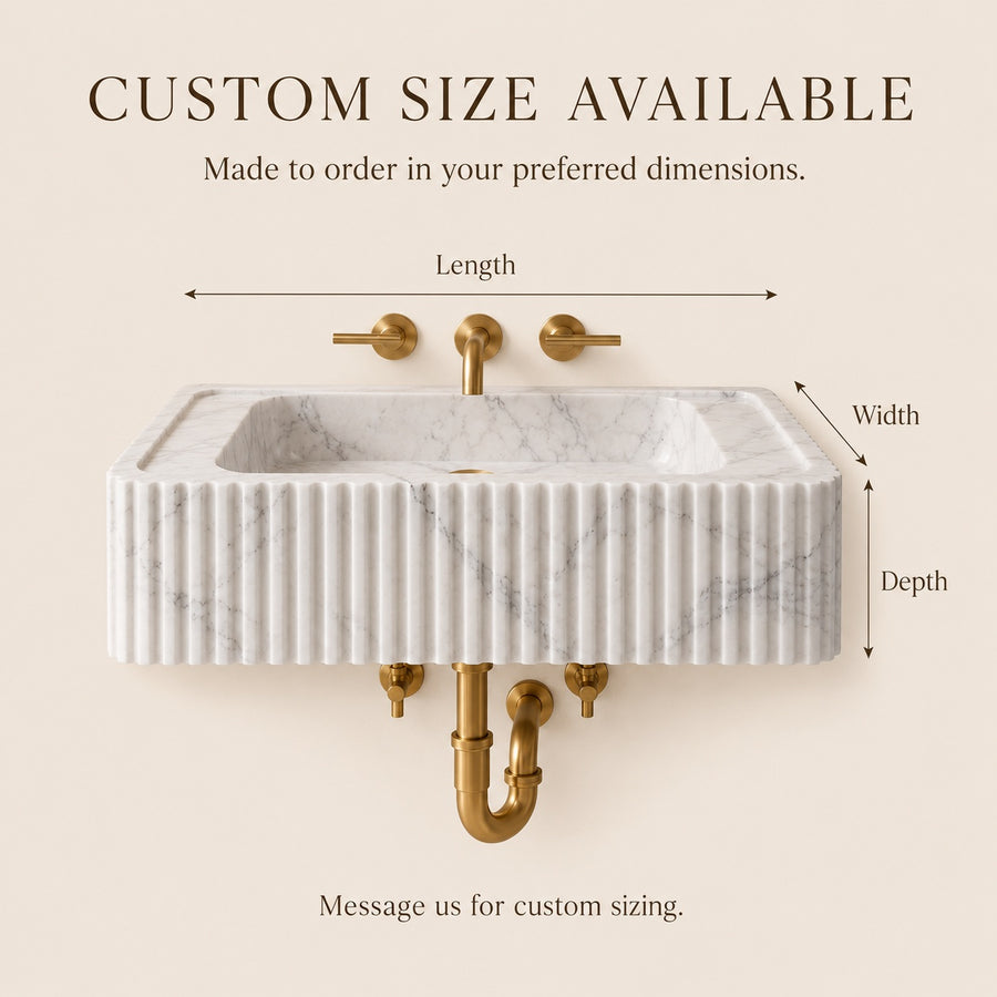 A wall-mounted rectangular sink with a white marble-look front, fluted vertical detailing, and gold faucet hardware on a beige background. Text at the top says 'CUSTOM SIZE AVAILABLE' with arrows labeling length, width, and depth, and additional text stating the sink is made to order.