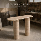 Beige stone table in a workshop setting with tools and materials.