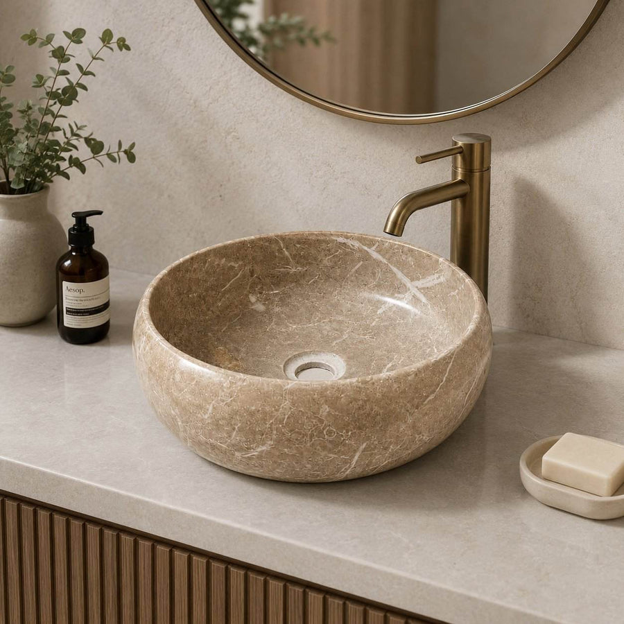 Bathroom vanity with stone sink, faucet, and decorative elements.