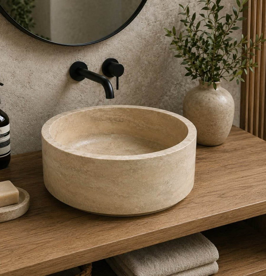 Bathroom vanity with a stone sink, black faucet, and decorative elements.