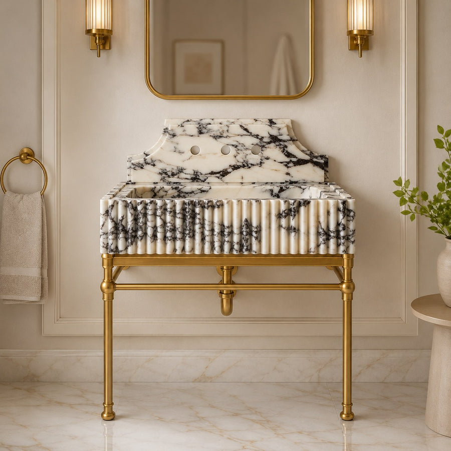 Fluted marble sink on brass console legs against cream paneled wall