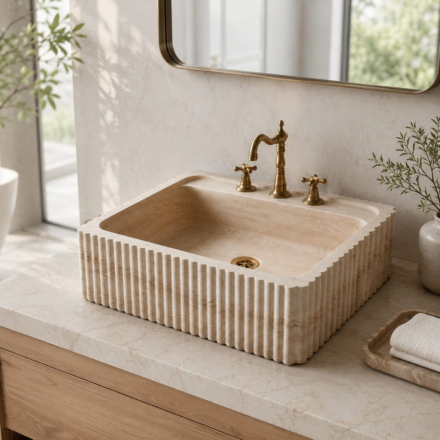 hand carved custom travertine sink in a modern bathroom