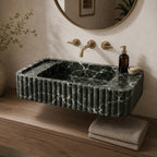 Green Levanto marble fluted sink on a wood vanity with brass faucet