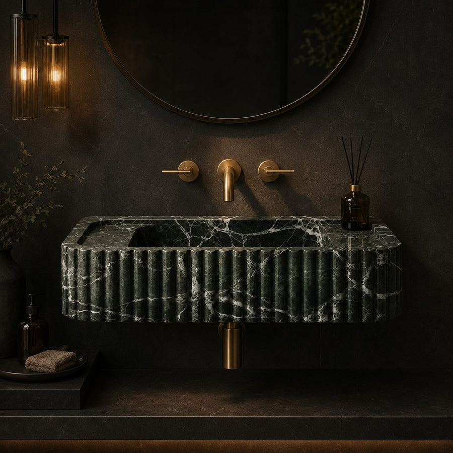 Green Levanto marble fluted sink in a dark moody bathroom with brass fixtures