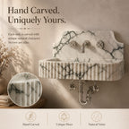 Hand-carved marble wall sink with a ribbed front, polished chrome faucet and drain, shown against a warm beige wall with marketing text and a circular detail inset.