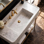 Bathroom with a modern marble sink and mirror on a wall.