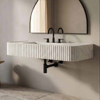 Bathroom with a modern sink and round mirror on a neutral wall.