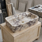 Handcrafted Calacatta Viola marble sink shown in a stone workshop