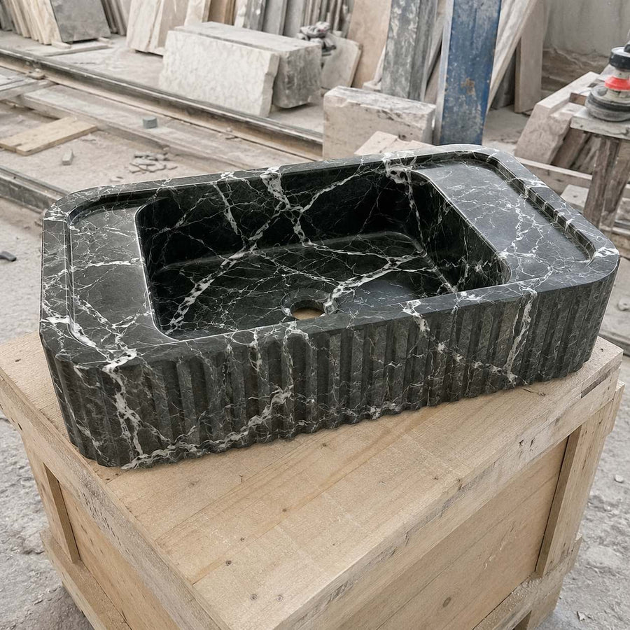 Handcrafted green Levanto marble sink shown in a stone workshop