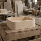 Handcrafted travertine sink shown in a stone workshop