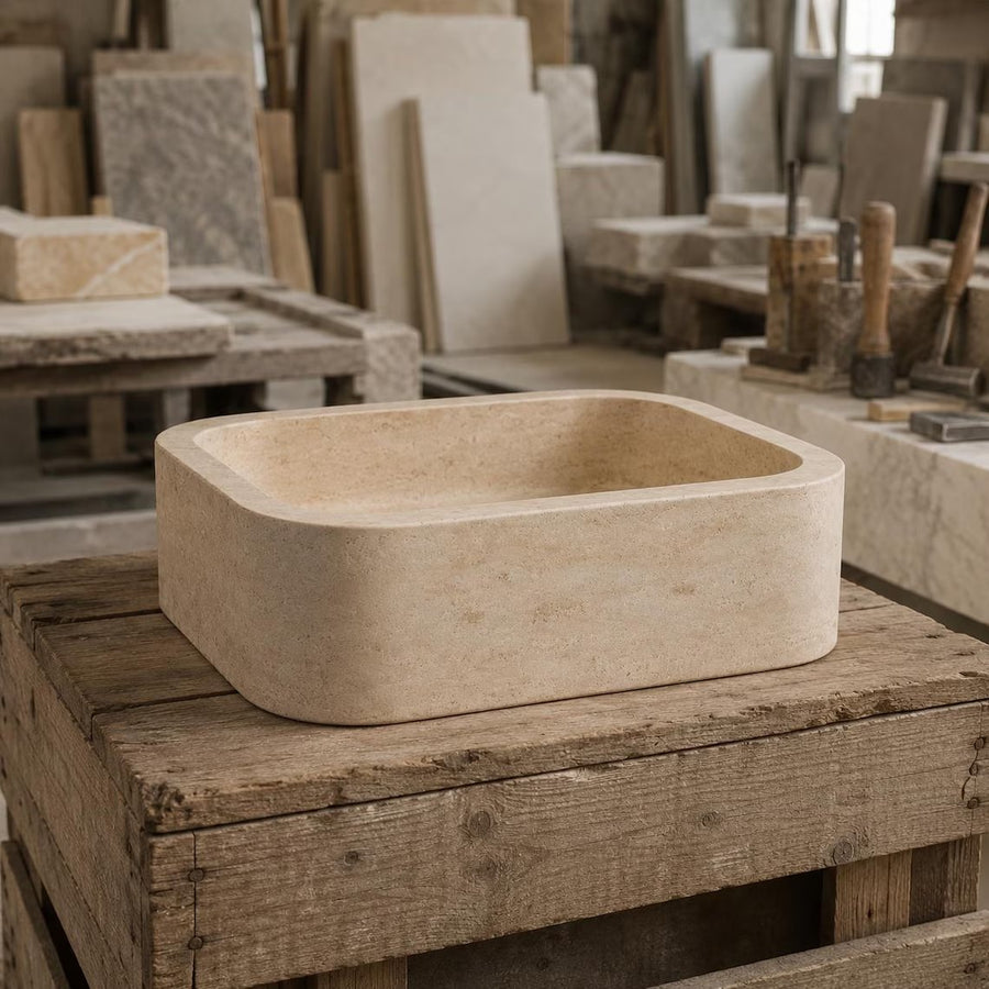 Handcrafted travertine sink shown in a stone workshop