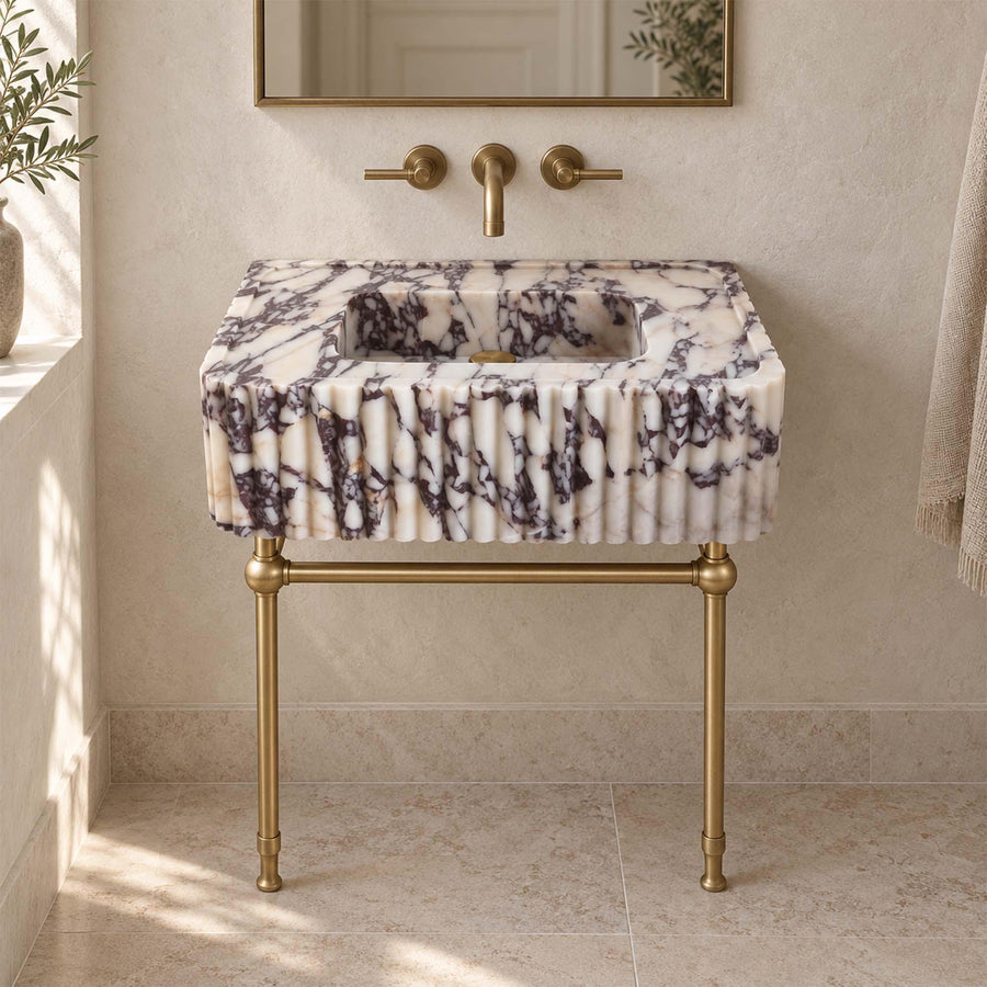 Rectangular Calacatta Viola marble sink with fluted exterior on a brass console stand with crossbar