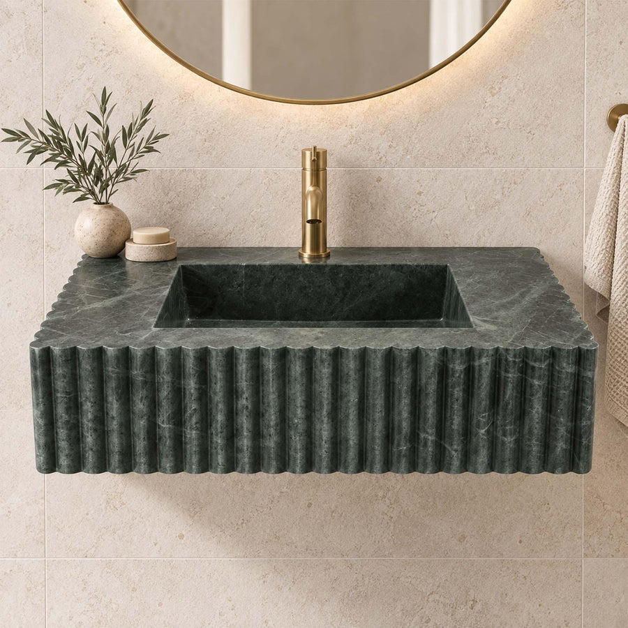 Green marble fluted wall-hung sink with antique brass faucet in a designer bathroom