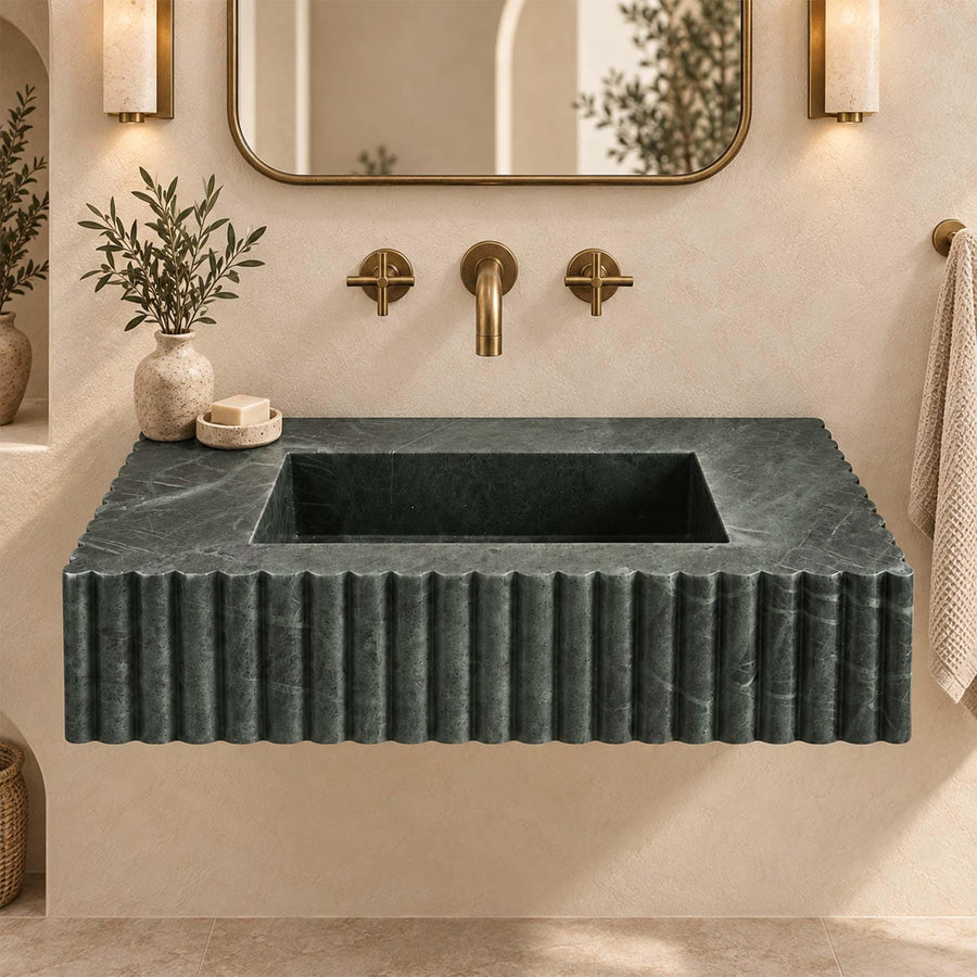 Green marble scalloped sink with wall faucet, towel and soap dispenser in a luxury bathroom